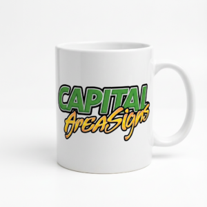 White ceramic mug featuring DTF transfer logo with green gradient "CAPITAL" text and orange gradient "AreaSigns" script applied on front, professional product photography