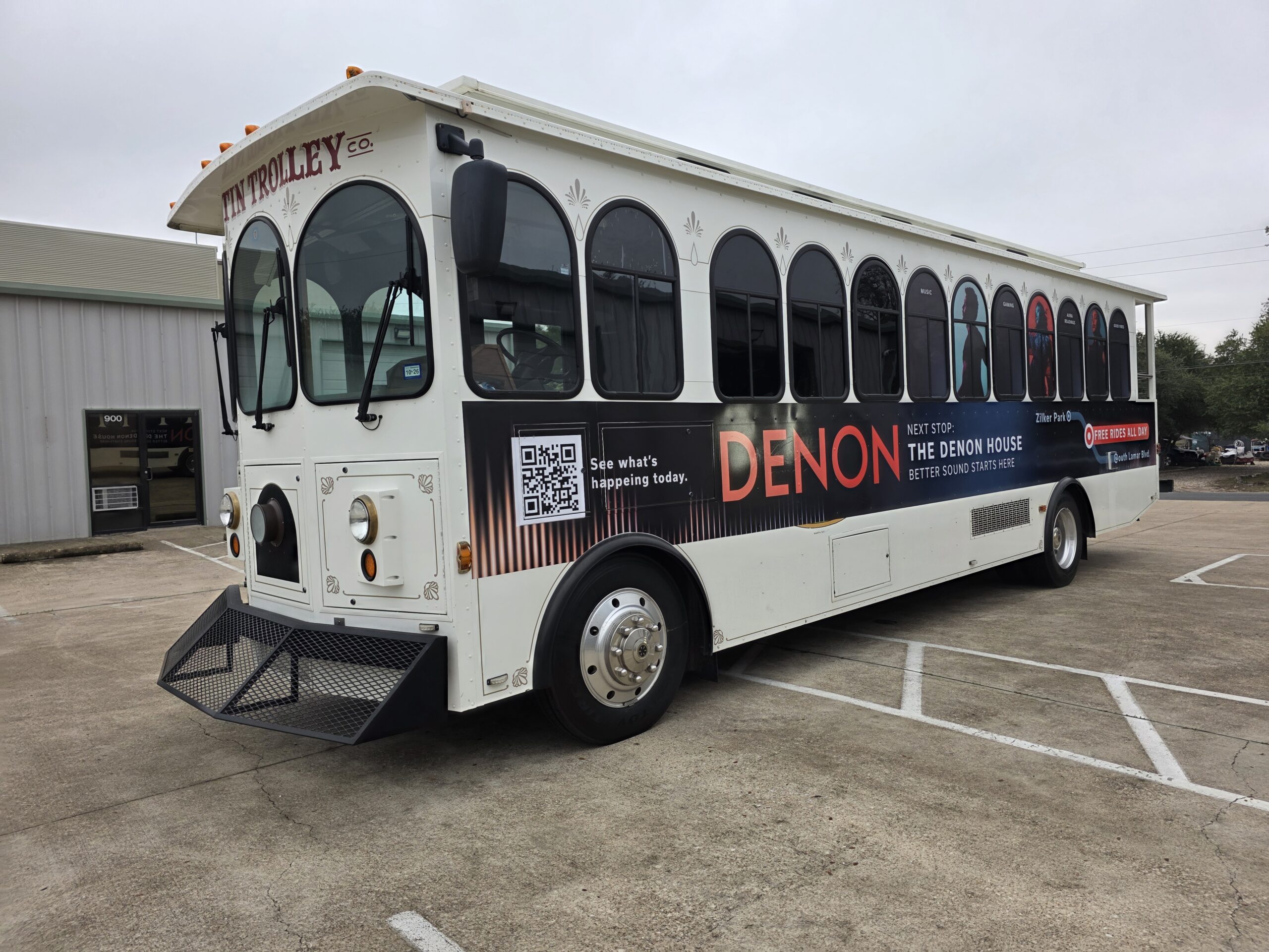 Promotional graphics along the side of a white trolley-style bus
